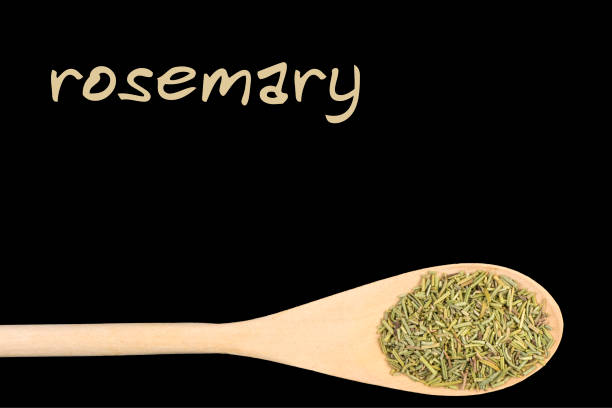 istock rosemary on wooden spoon isolated on black background 1128457324