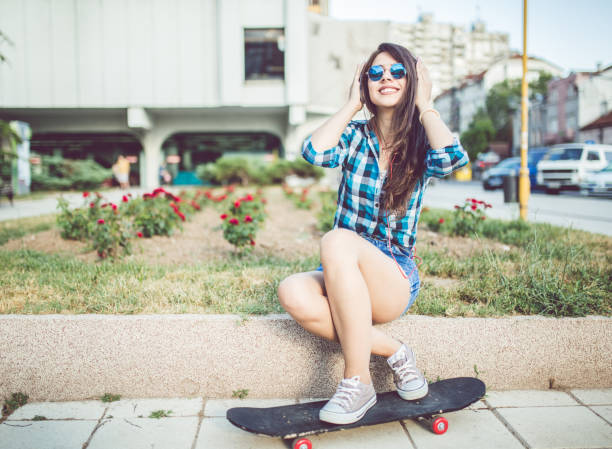 istock Girl in checkered shirt with skateboard 1128458066