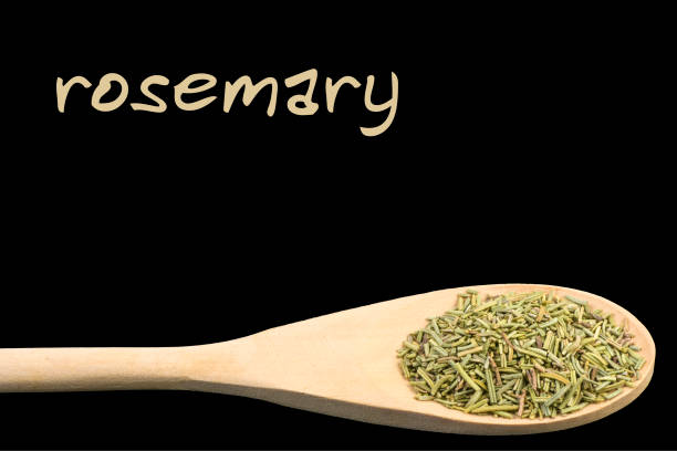 istock rosemary on wooden spoon isolated on black background 1128458131