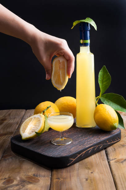 limoncello in bottiglia e un piccolo colpo con liquore. la bevanda alcolica tradizionale d'italia, dagli agrumi. frutta e bevande fresche. spazio libero per il testo. mano nel telaio. - neapolitan specialty foto e immagini stock