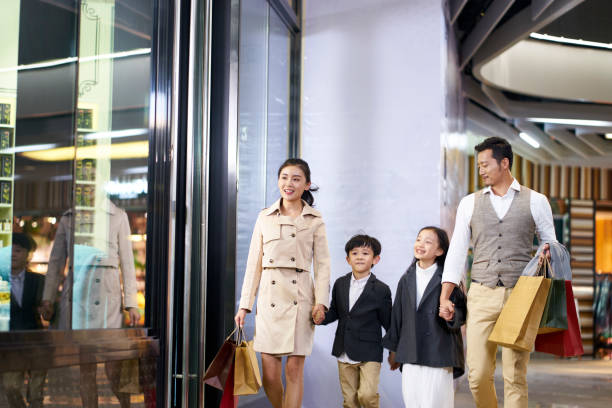 asian family walking in shopping mall happy asian family with two children walking in shopping mall shopping asia stock pictures, royalty-free photos & images