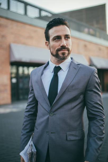 istock Modern gentleman in suit holding newspaper 1128459528
