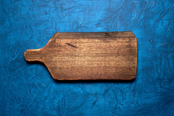 istock Old vintage cutting board on a blue background. 1128461422