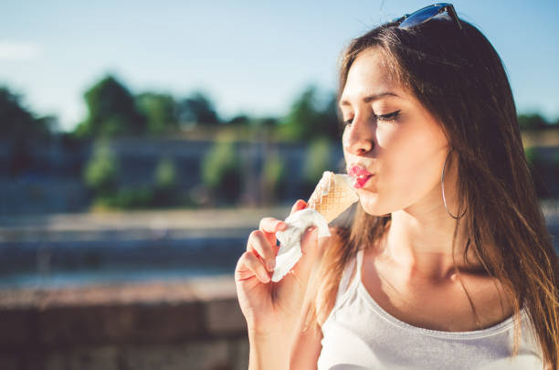 istock Girl licking ice cream 1128464633
