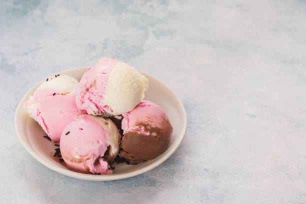 istock Bowl of Neapolitan ice cream scoops on rustic background 1128467542