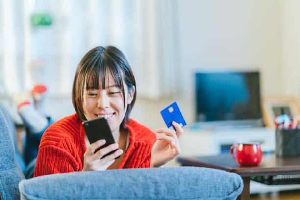 若い女性が自宅のオンライン ショッピング - e commerce credit card retail paying ストックフォトと画像