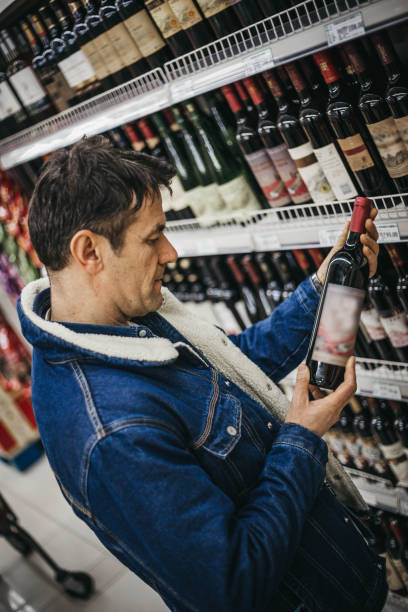 istock Man choosing a wine in a supermarket 1128467697