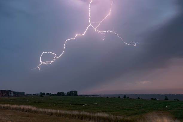 istock A bright lightning bolt in the clouds during a severe thunderstorm in Holland 1128467735