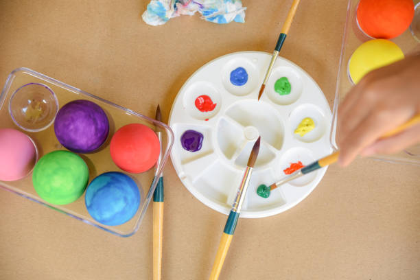 istock Happy Easter Day. Easter eggs concept. A girl hand painting Easter eggs. Happy family preparing for Easter. 1128469552