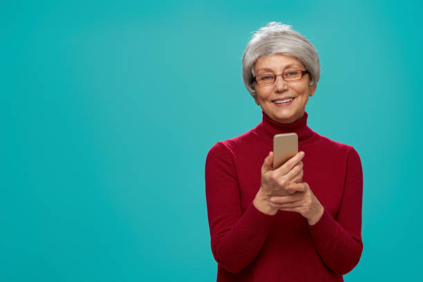 istock senior woman on teal background 1128470246