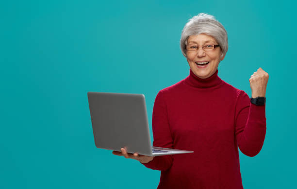 istock senior woman on teal background 1128470280
