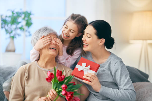 szczęśliwy dzień kobiet - grandmother giving gift child zdjęcia i obrazy z banku zdjęć