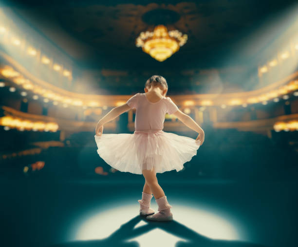 girl dreaming of becoming a ballerina Cute little girl dreaming of becoming a ballerina. Child girl in a pink tutu dancing on the stage. Baby girl is studying ballet. performing arts event stock pictures, royalty-free photos & images