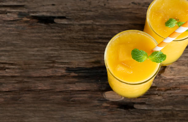 istock Mango smoothies yellow colorful fruit juice milkshake blend beverage healthy high protein the taste yummy In glass drink to lose weight drink episode morning on a wooden background from top view. 1128474078