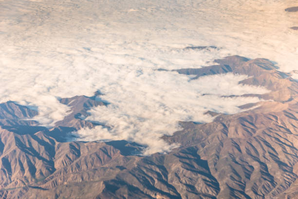 istock Wing of an airplane flying above the clouds with blue sky.(blacksea) 1128475882