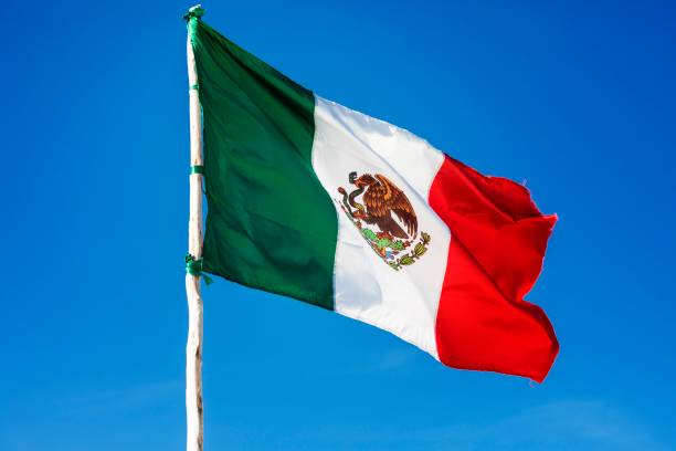 drapeau national mexicain du mexique flottent au vent sur un beau ciel bleu des caraïbes sur la côte de la riviera maya en amérique du sud - place mat photos et images de collection