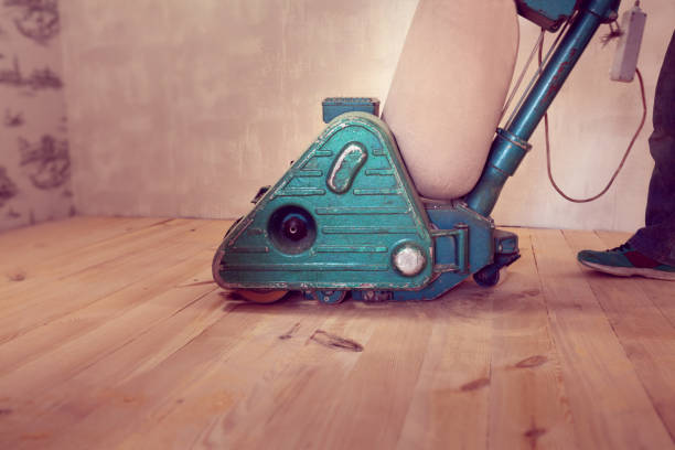 istock carpenter works by electric grinding wood machine in a room 1128480014