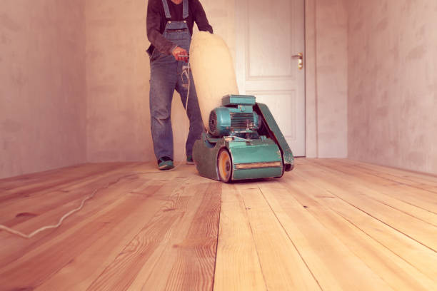 carpenter works by electric grinding wood machine in a room carpenter polishes a wooden floor by electric grinding wood machine in a room sand paper stock pictures, royalty-free photos & images