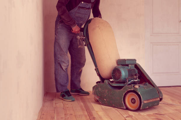 istock carpenter works by electric grinding wood machine in a room 1128480022