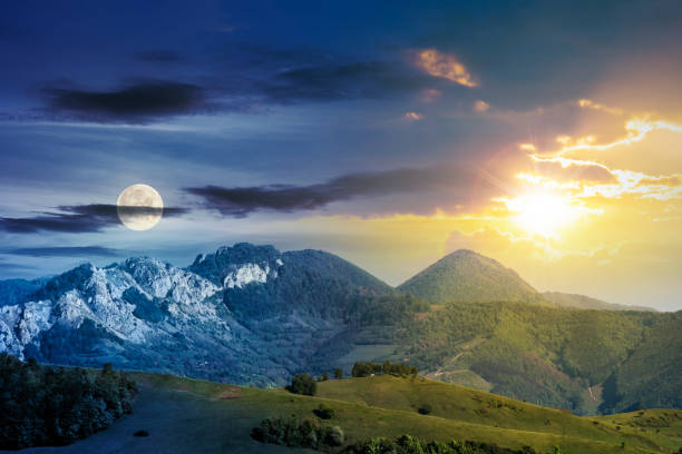 day and night time change concept above mountains with rocky formations. grassy meadows, forested hills and huge cliffs. wonderful nature scenery. beautiful weather in springtime with sun and moon