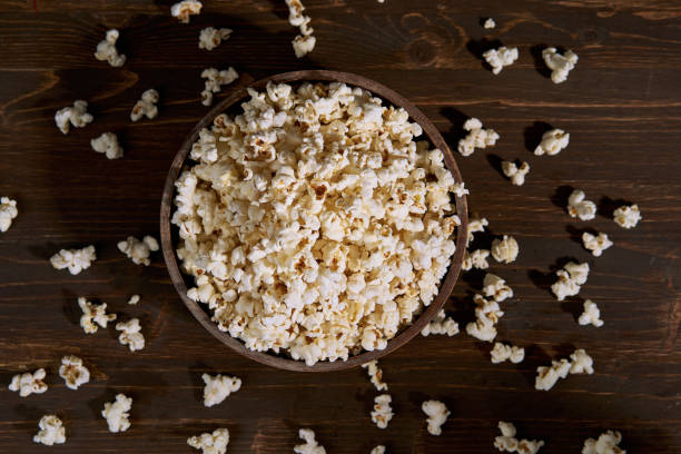 Popcorn Stock photo of popcorn on dark background popcorn snack bowl isolated stock pictures, royalty-free photos & images