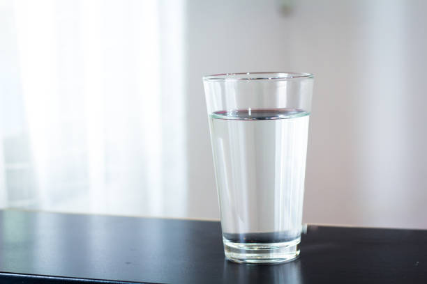 istock Glass of water on the table background 1128487213