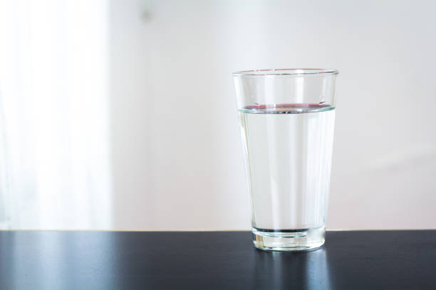 istock Glass of water on the table background 1128487753