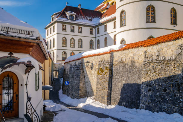 St. Mang's Abbey (Kloster Sankt Mang) at winter in the snowy historic old town of Füssen, a romantic medieval city on the Romantic Road in Bavaria, Germany St. Mang's Abbey (Kloster Sankt Mang) at winter in the snowy historic old town of Füssen, a romantic medieval city on the Romantic Road in Bavaria, Germany. st mang stock pictures, royalty-free photos & images