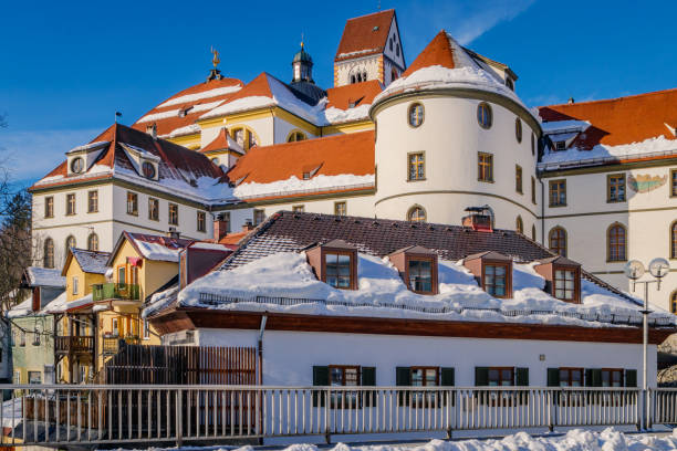 St. Mang's Abbey (Kloster Sankt Mang) at winter in the snowy historic old town of Füssen, a romantic medieval city on the Romantic Road in Bavaria, Germany St. Mang's Abbey (Kloster Sankt Mang) at winter in the snowy historic old town of Füssen, a romantic medieval city on the Romantic Road in Bavaria, Germany. st mang stock pictures, royalty-free photos & images