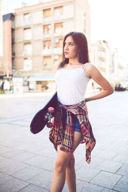 istock Girl carrying her skateboard 1128490602