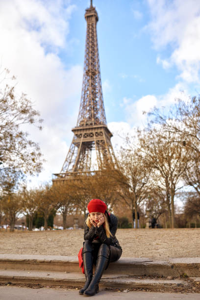 young nostalgic woman in Paris sitting on the street and thinking far away.