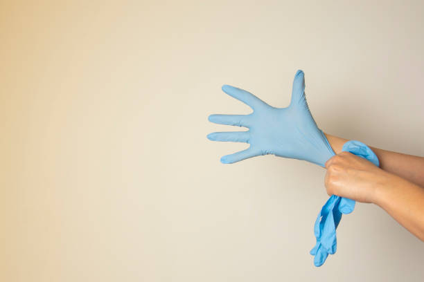 медсестра или косметолог надевая медицинские латексные перчатки изолированы. копирование пространства. - sports glove protective glove equipment protection стоковые фото и изображения