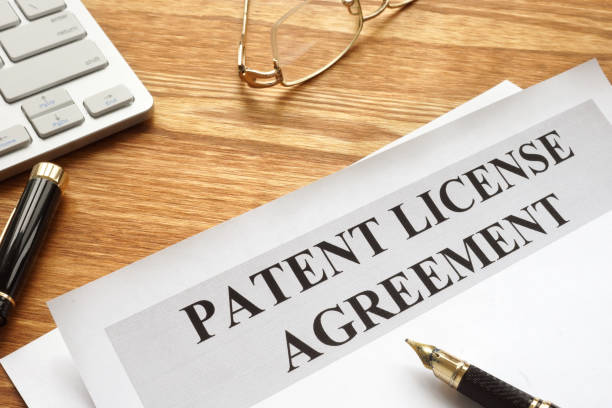 istock Patent license agreement with pen and glasses. 1128492146