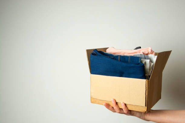 istock Donation concept. Hands holding donate box with clothes. Copy space. 1128492716