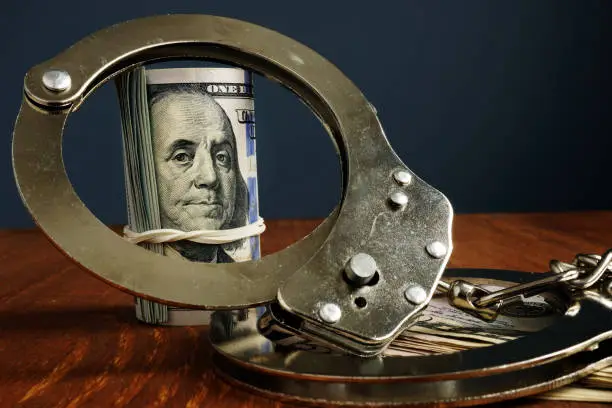 Photo of Penalty or bail bond concept. Money and handcuffs.