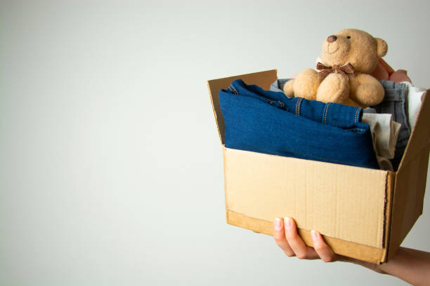 istock Donation concept. Hands holding donate box with clothes. Copy space. 1128492743