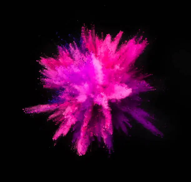 Multi colored powder explosion isolated on black background. Freeze motion of abstract dust texture.