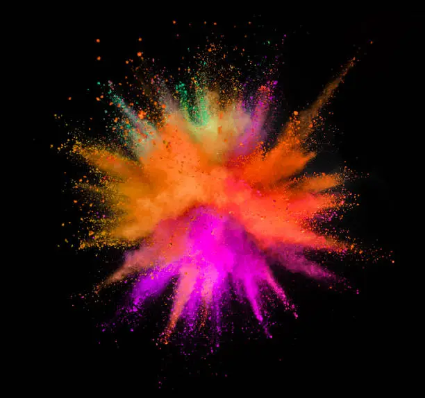 Multi colored powder explosion isolated on black background. Freeze motion of abstract dust texture.