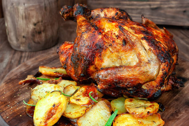 istock Roasted chicken with potato on wooden table 1128495226