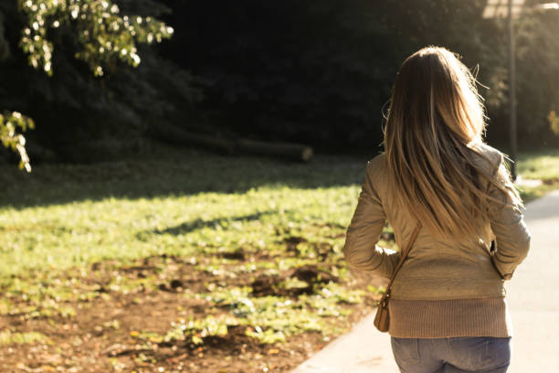 istock Woman walking at sunset 1128498075