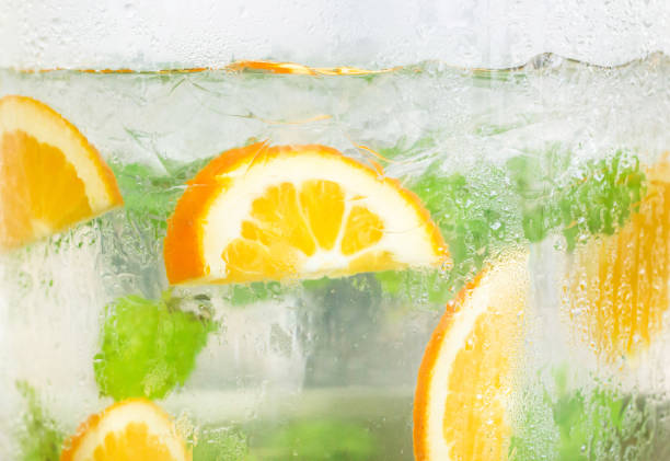 cold detox water with orange slices and mint leaves, background. - healthy drink imagens e fotografias de stock