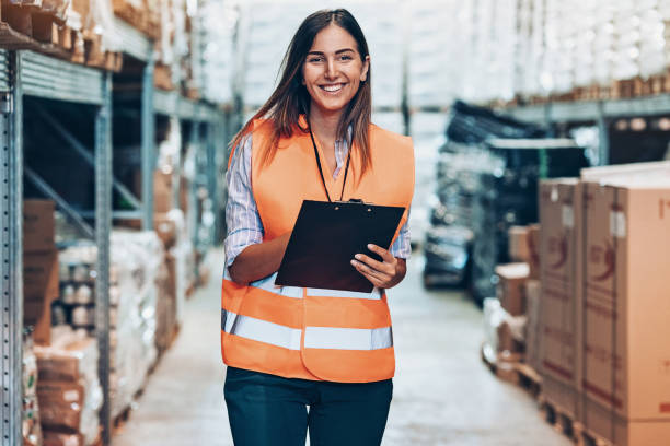 istock Smiling woman working in a warehouse 1128505173