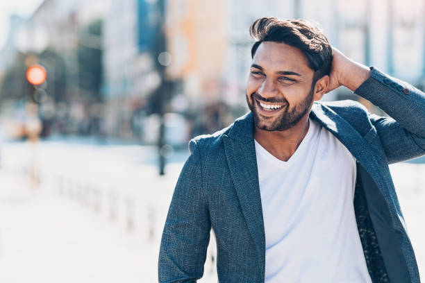 origen étnico indio joven feliz hombre de la calle - mano en el cabello fotografías e imágenes de stock