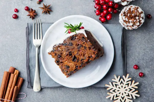 Photo of Christmas fruit cake, pudding on white plate. Copy space. Top view.