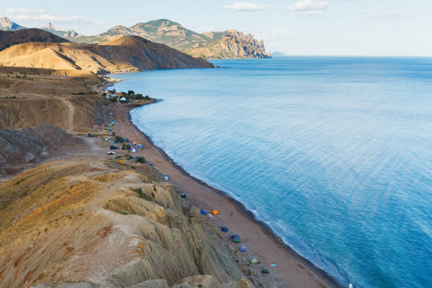 istock Wild sea bay with people and tents 1128507532