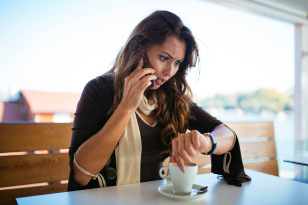 Anxious woman looks at the clock in a cafeteria