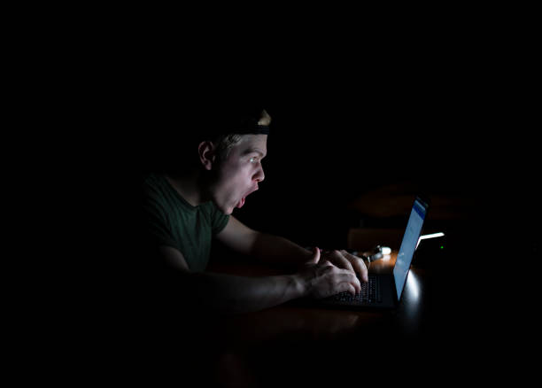 istock Man works at a laptop at night 1128508315
