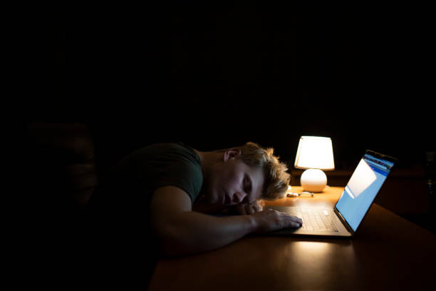 istock Man sleeps near a laptop at night 1128509403
