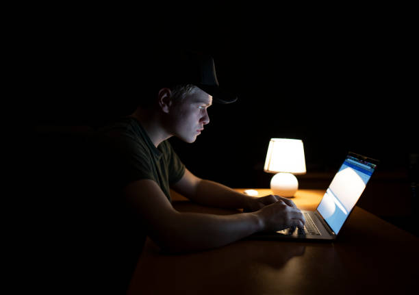 istock Man works at a laptop at night 1128509454