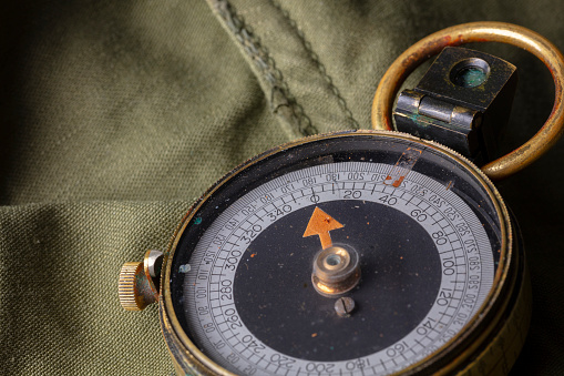 Close up of a antique engineering compass on a military uniform.